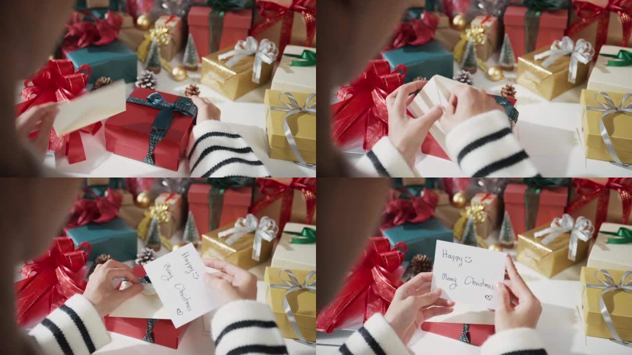 女孩手的特写打开礼物礼品盒红色背景的冬季圣诞装饰品。
