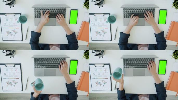 女性双手在办公室与笔记本电脑一起工作的俯视图，而绿色色度键屏幕智能手机在桌子上可见