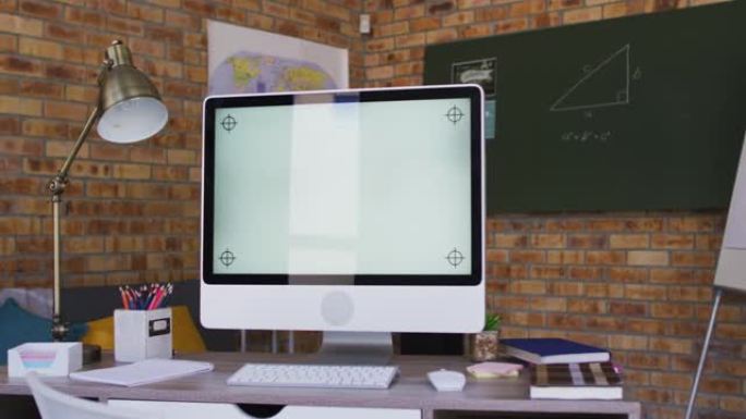 在学校教室的桌子上查看计算机和其他学校用品