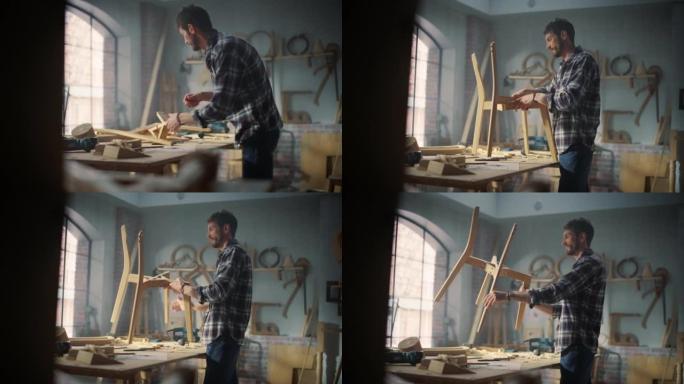 年轻快乐的木匠组装木椅的零件。专业家具设计师在阁楼空间的车间工作，墙壁上有工具。