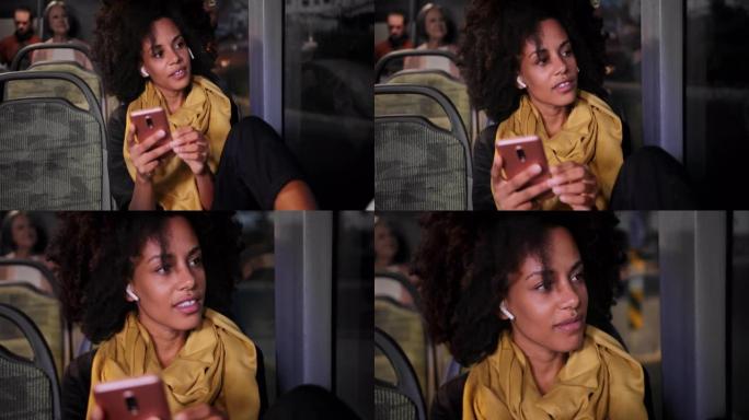 坐在公共汽车上的耳机和智能手机的特写非裔美国妇女