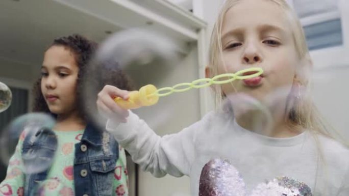 两个小女孩在外面粘合时吹泡泡的4k视频片段