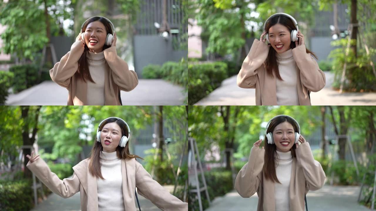 亚洲女人戴着耳机听音乐，享受音乐