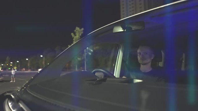 男人晚上开车。具有全息层的视频