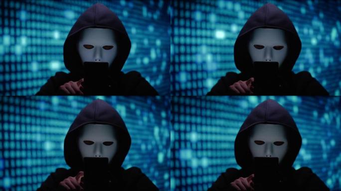 匿名计算机黑客在屏幕上使用电话和二进制代码