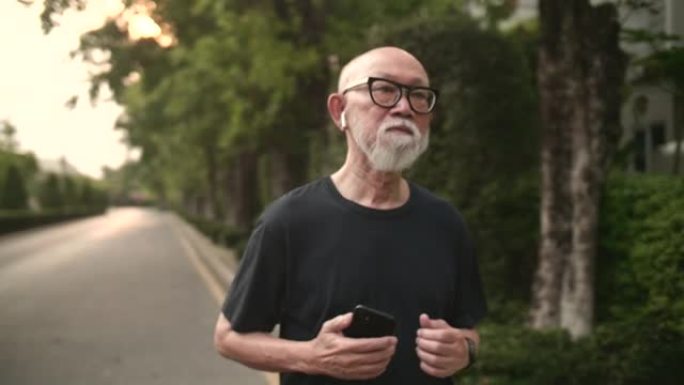 亚洲资深男子手持手机跑步