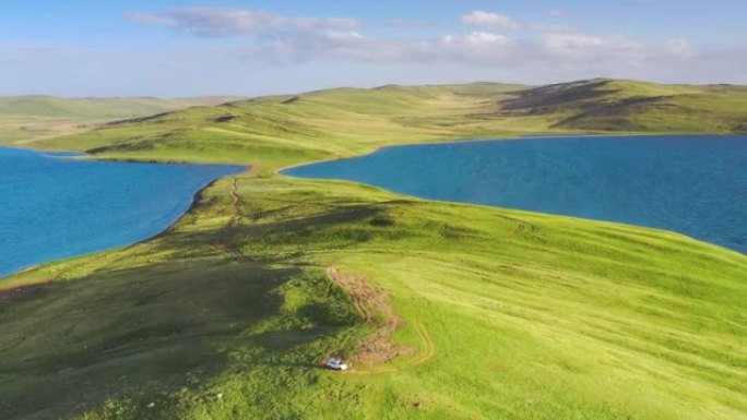 在青藏高原的湖中，有一个充满绿色草原的半岛
