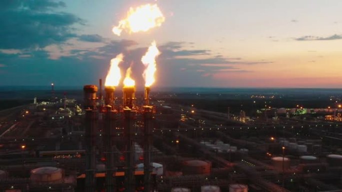 石油精炼厂的火炬堆在日落时放火