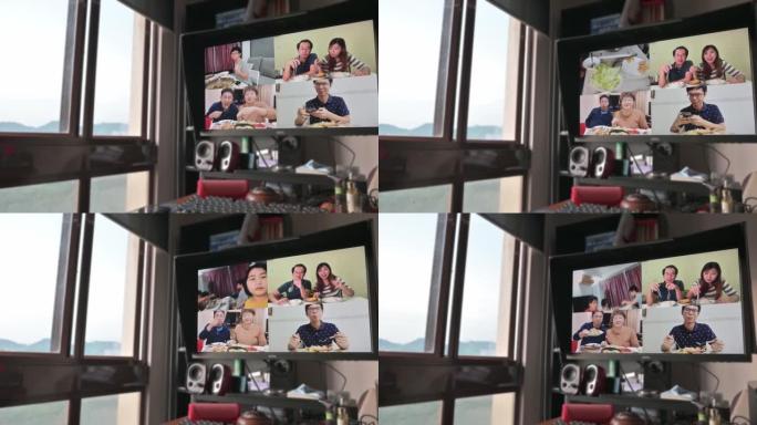 晚餐时间，亚洲中国中年女性和家人朋友一起在台式电脑显示器屏幕前观看视频