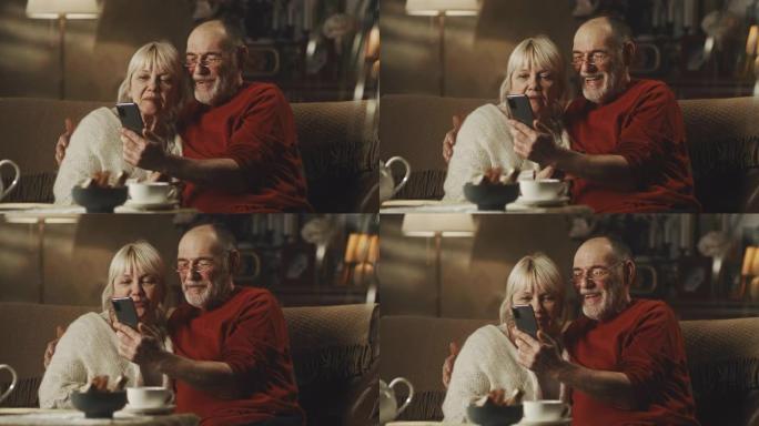 愉快的老年夫妇拥抱并进行视频通话