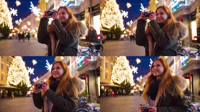 微笑的女人在装饰精美的城市享受圣诞精神，拍照