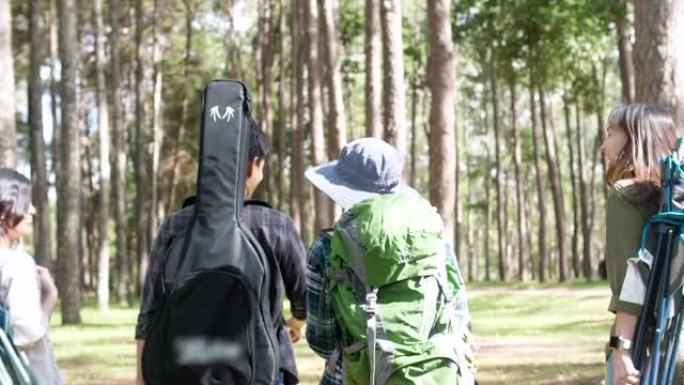 一群朋友在森林里散步和徒步露营