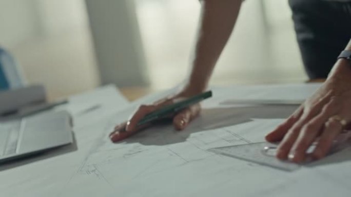 女建筑师或工程师在从事建筑项目时设计蓝图。一名妇女绘制建筑平面图