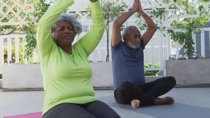 轻松的非洲裔美国高级夫妇在露台上的垫子上练习瑜伽的动画