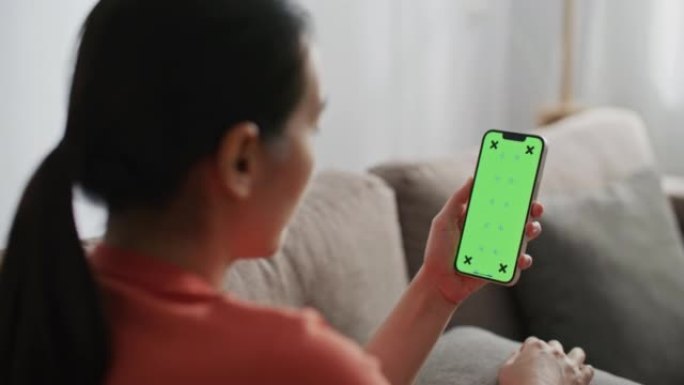 女性在家中使用绿屏模板智能手机