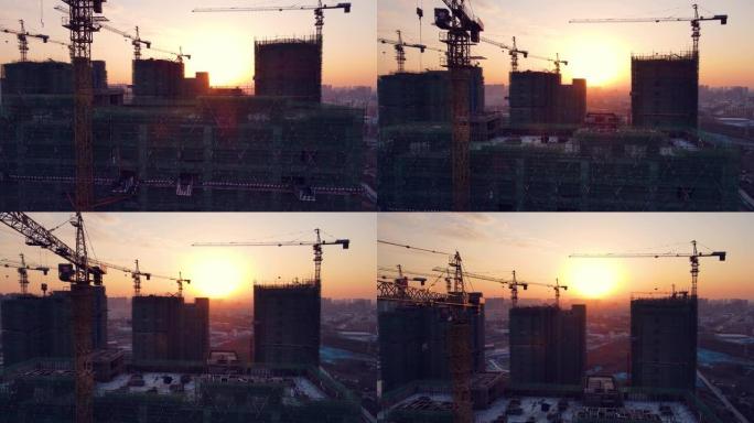 日落时建筑工地起重机的空中后视图