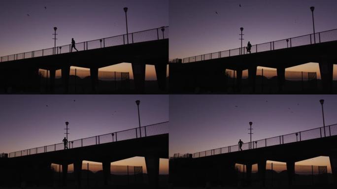 晚上在桥上奔跑的人的剪影