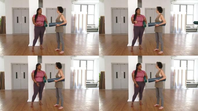 两名妇女在健身房瑜伽训练后交谈
