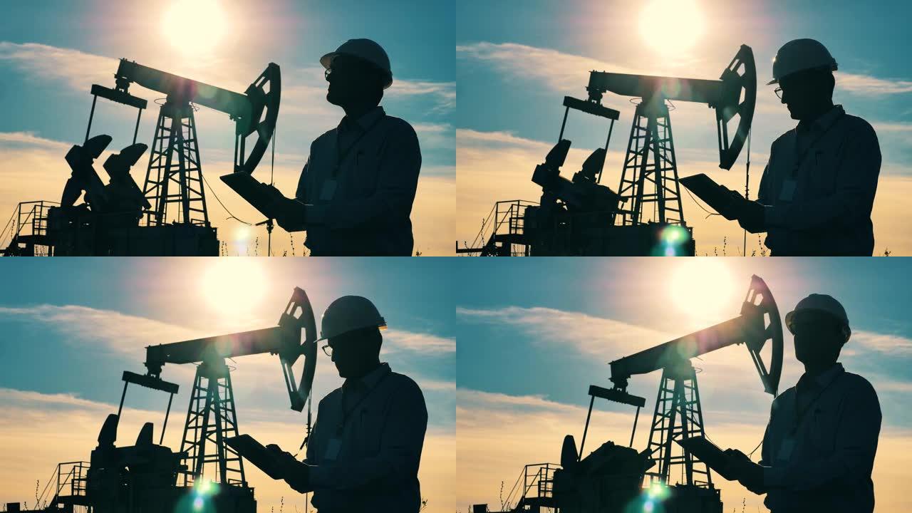 化石燃料，原油概念。电力工人正在观察石油开采地点并操作平板电脑