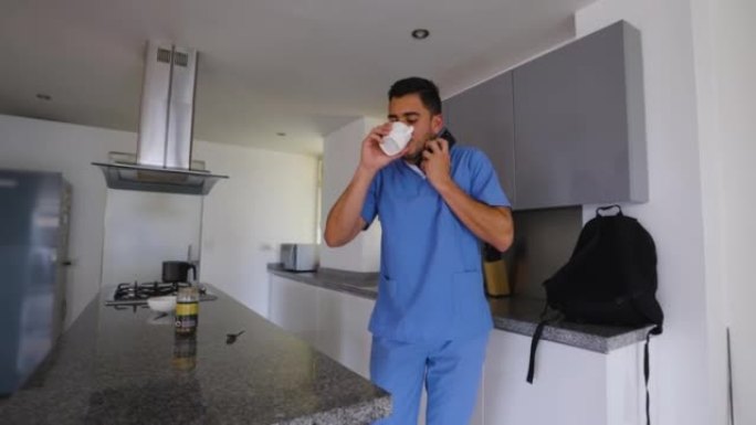 年轻的男医生在打电话时喝咖啡，匆忙离开去医院换班