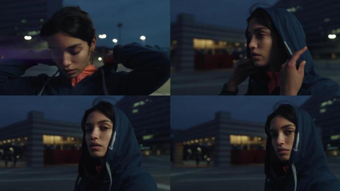 年轻的阿拉伯女运动员戴上引擎盖并看着镜头的电影特写镜头，然后晚上在市中心奉献精神。决心、女性力量和运