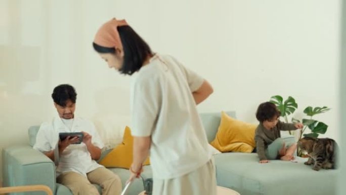 无忧无虑的亚洲家庭在沙发、家庭客厅一起玩耍