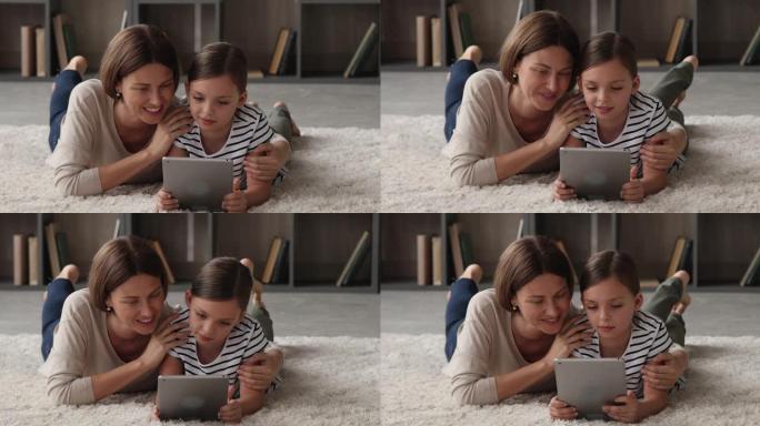 结合年轻的母亲和小女儿玩平板电脑。