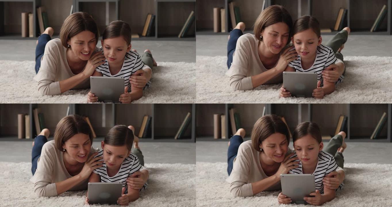 结合年轻的母亲和小女儿玩平板电脑。