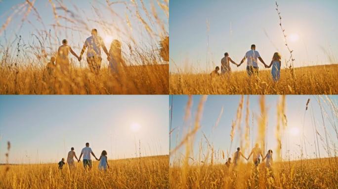 带着两个孩子的SLO MO家庭在黄金时段在高高的羊茅草丛中行走