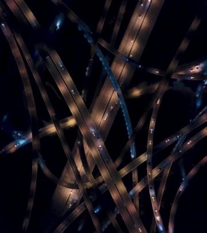 复杂立交桥和夜间繁忙交通的鸟瞰图