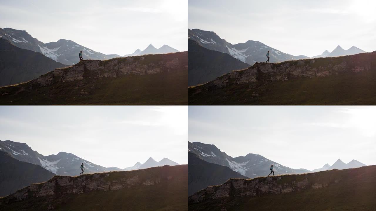 年轻女运动员徒步旅行落基山山脊环绕雄伟的山峰