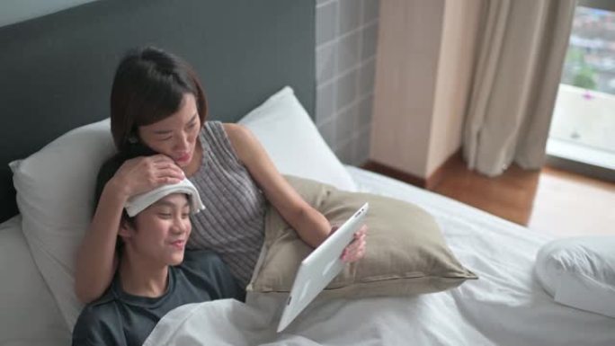 远程医疗亚洲中国母亲担心触摸儿童额头使用数字平板电脑与医生交流