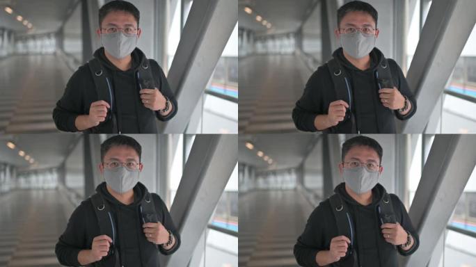 一名亚洲华人戴着防护口罩走在城市的桥上，在市中心通勤上班