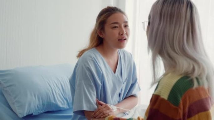 年轻的亚洲人在床上探望病人。