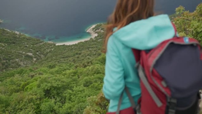 站在山顶上的女徒步旅行者的后视图