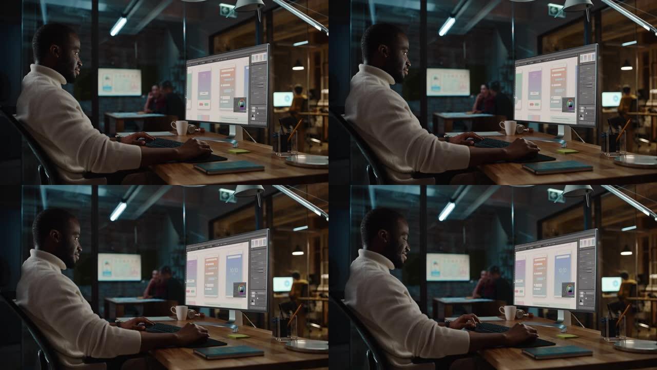 英俊的黑人非洲裔美国人在创造性的办公环境中工作在台式电脑上。有色人种正在数字图形编辑软件中开发新的应