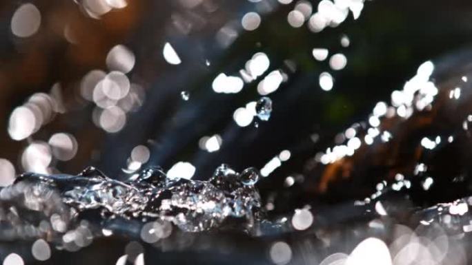 超级SLO MO特写镜头水从河里的岩石上流下，在底部溅水