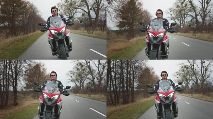 骑自行车的人骑着旅游摩托车在路上。英俊的男人驾驶时尚的红色摩托车。两轮旅行概念。慢动作镜头
