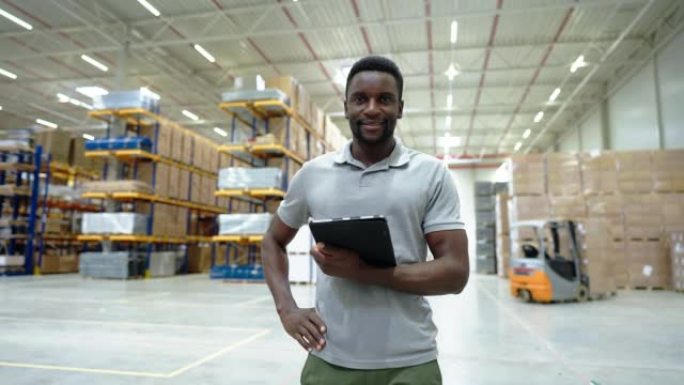 站在大型工厂仓库的数字平板电脑的非洲男子