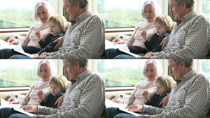 带着孙子在沙发上看书的祖父母