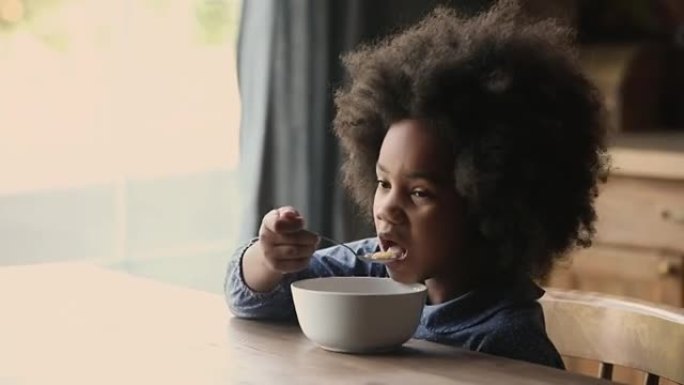 小有趣卷曲的非洲裔美国孩子吃早餐。