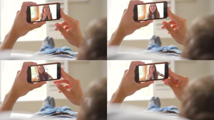 一个无法识别的男子使用智能手机进行视频通话的4k视频片段
