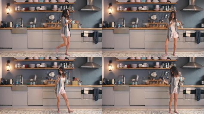 4k视频片段，一名年轻女子在家里喝咖啡和在厨房跳舞时使用电话