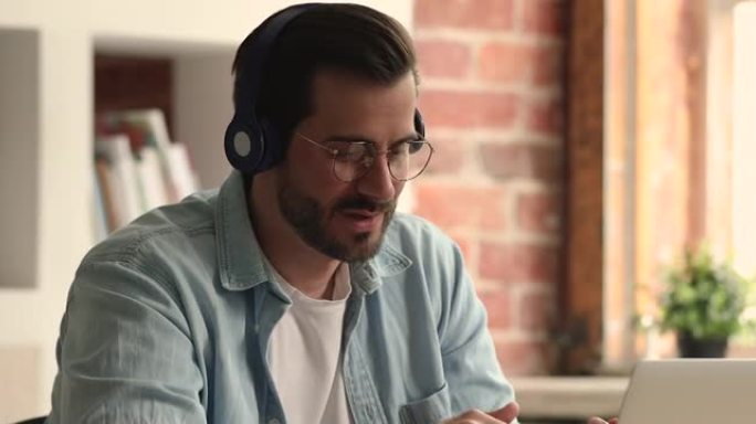 男人戴着无线耳机使用笔记本电脑参加视频会议
