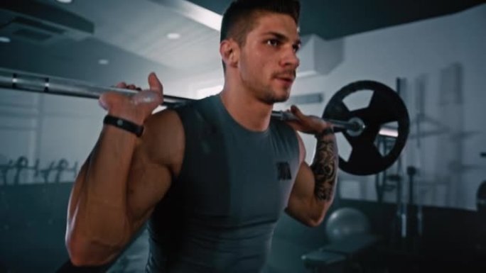 男性健美运动员在健身房做杠铃深蹲