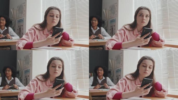 女孩在课堂上使用智能手机
