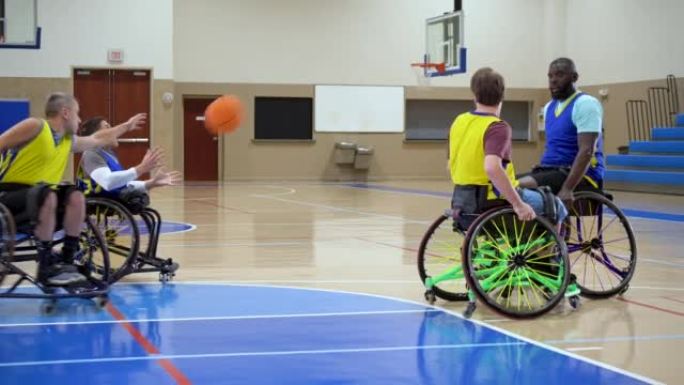 四名男子打轮椅篮球，传球和运球
