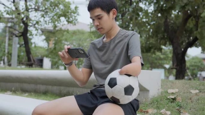 瘫痪的亚洲男子在比赛，比赛或训练后用电话放松。