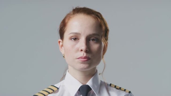 在朴素的背景下，严肃的女飞行员或船长的工作室肖像