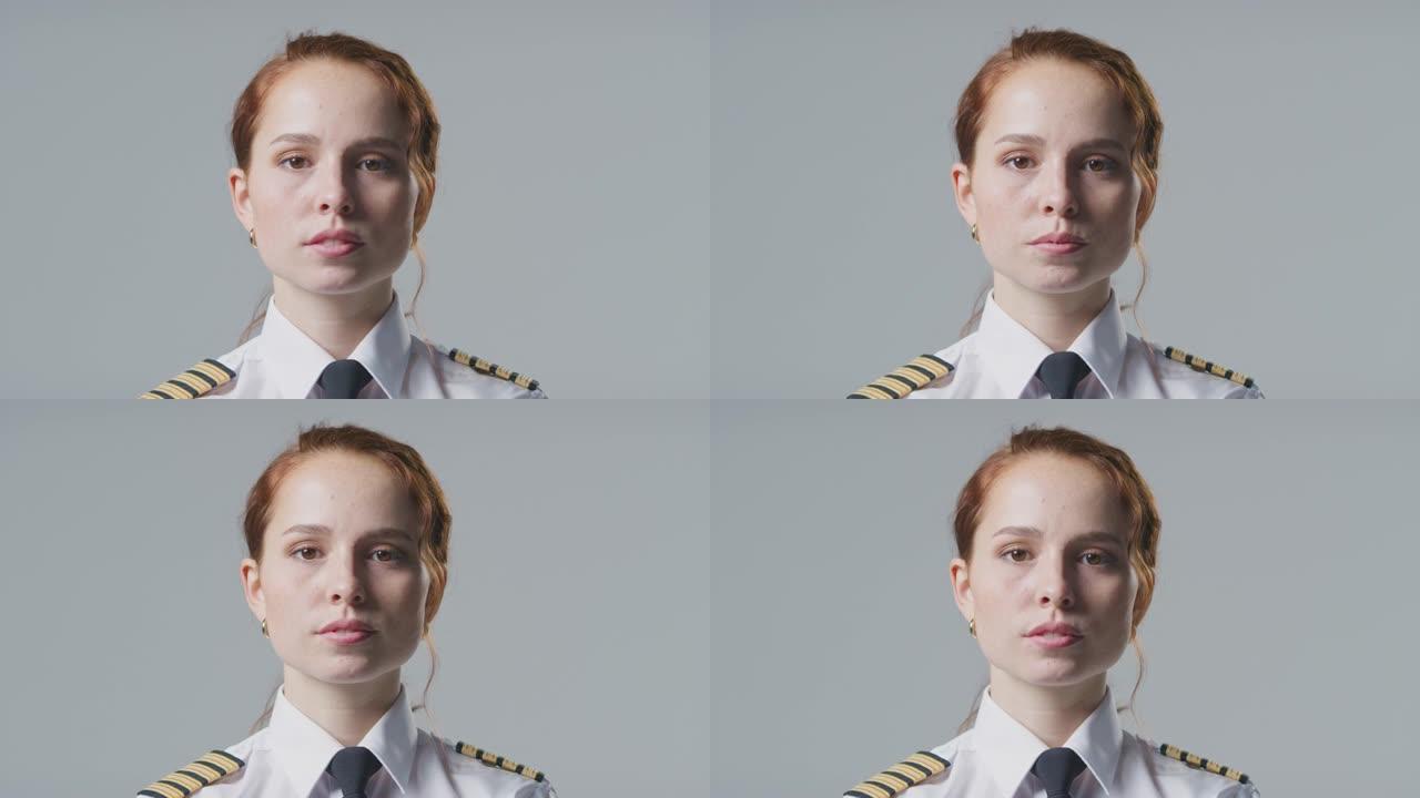 在朴素的背景下，严肃的女飞行员或船长的工作室肖像